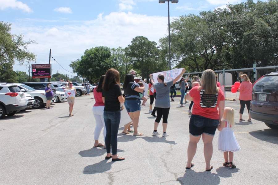 Families and CCISD administrators gathered in the parking lots of each honoree's respective campus with congratulatory messages on homemade signs. (Colleen Ferguson/Community Impact Newspaper)