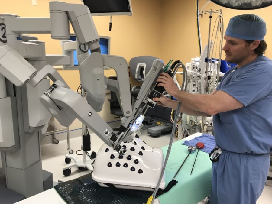 Dr. Wade Dunlap, a general surgeon at St. David’s Georgetown Hospital, adjusts some of the instruments on the robot. When operating the equipment during a procedure, he sits at a console and guides the instruments remotely. (Courtesy St. David's HealthCare)