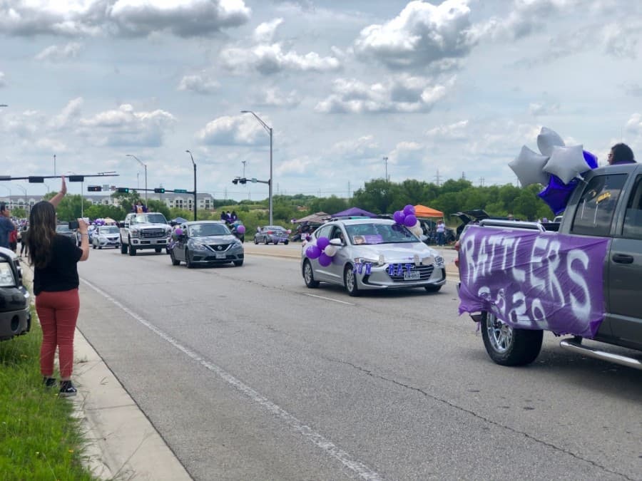 Parade vehicles were decorated with white and purple colors to honor the Rattler graduates. (Evelin Garcia/ Community Impact Newspaper)