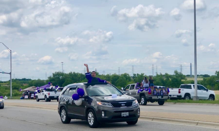 Rattler graduates waved and cheered as they drove by the crowds. (Evelin Garcia/ Community Impact Newspaper)
