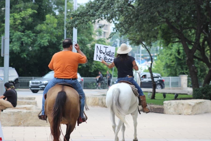 A pair riding horses through downtown on May 31. (Christopher Neely/Community Impact Newspaper)