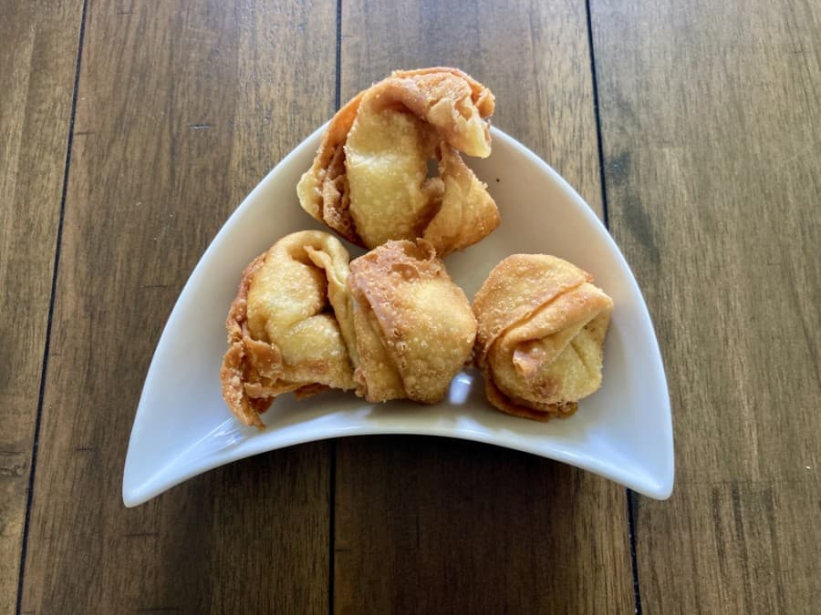 Crab rangoons are filled with cream cheese and crab meat and served with sweet and sour sauce. (Taylor Jackson Buchanan/Community Impact Newspaper)