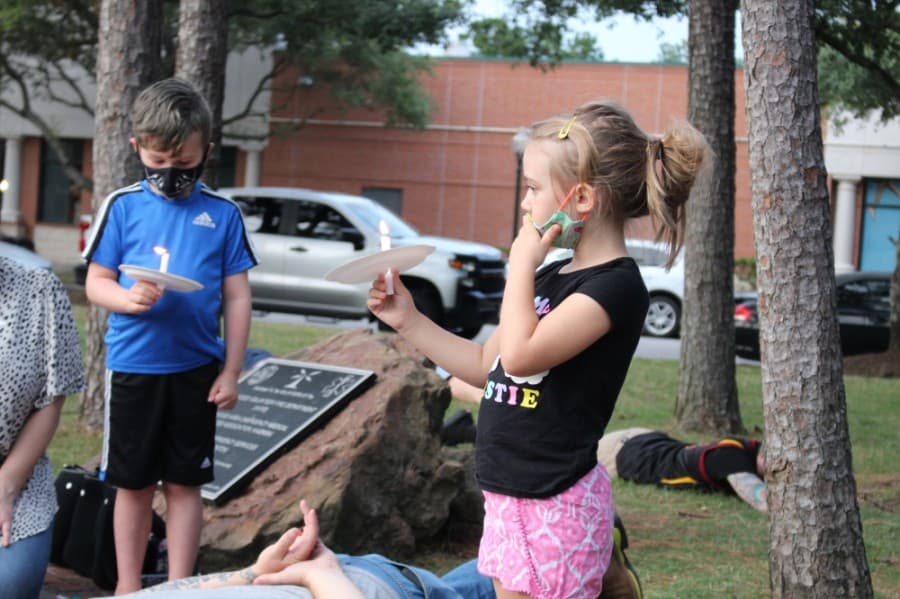 A young attendee holds a candle at the protest honoring George Floyd. (Kelly Schafler/Community Impact Newspaper)