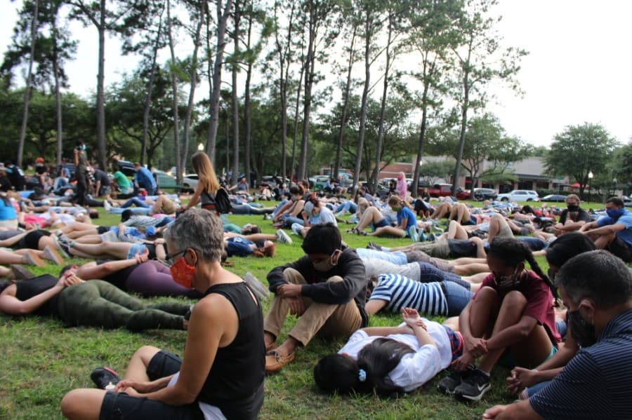 Protesters at the Kingwood event lay and sit on the grass of Town Center Park on June 1. (Kelly Schafler/Community Impact Newspaper)