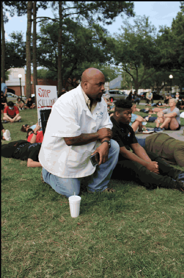 Some protesters kneel on the grass of Town Center Park on June 1. (Kelly Schafler/Community Impact Newspaper)