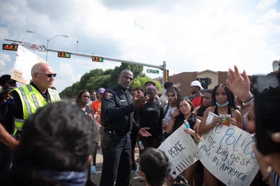 The crowd gathered around Police Chief Ed Drain at the end of the march. He encouraged people to stay and ask questions. (Liesbeth Powers/Community Impact Newspaper)