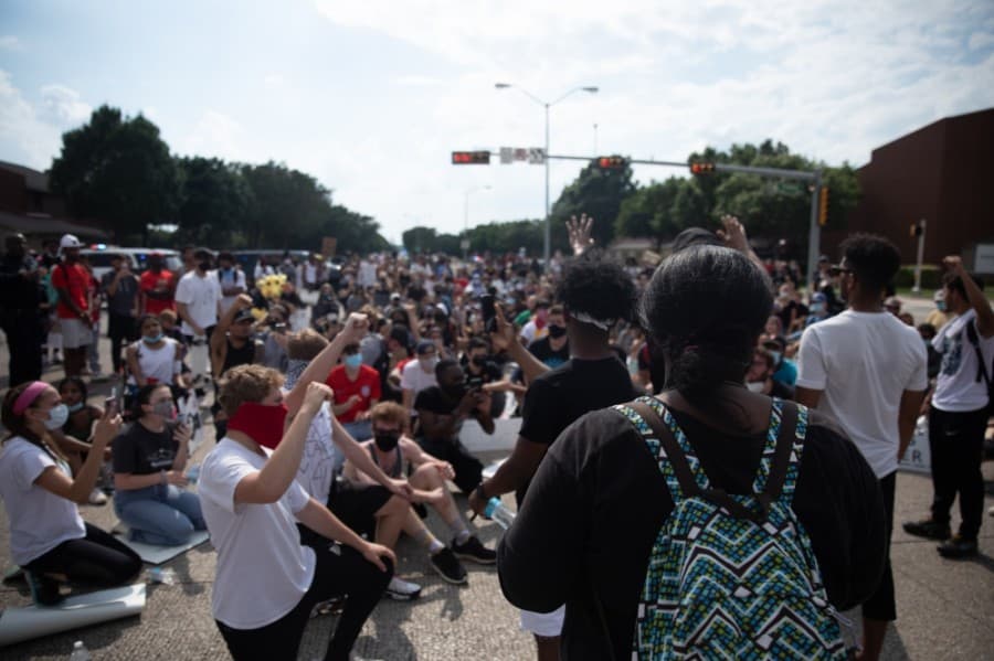 The group knelt and raised their fists in protest of police brutality and the death of George Floyd in Minneapolis. (Liesbeth Powers/Community Impact Newspaper)