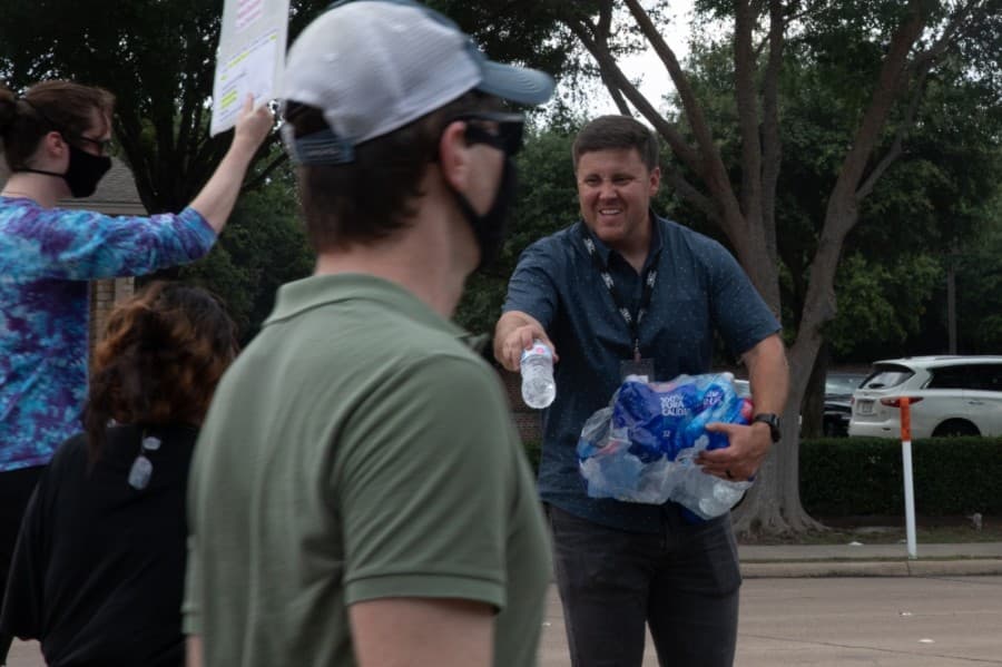 Grace Church Plano staff and volunteers, including Executive Pastor Jessie Prince, offered water and snacks to those passing by. (Liesbeth Powers/Community Impact Newspaper)