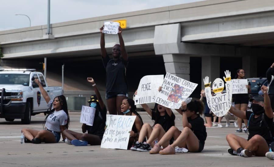 Some of the protesters sat in front of stopped traffic on Parker Road and Dallas Parkway, encouraging drivers to honk their horns. (Liesbeth Powers/Community Impact Newspaper)