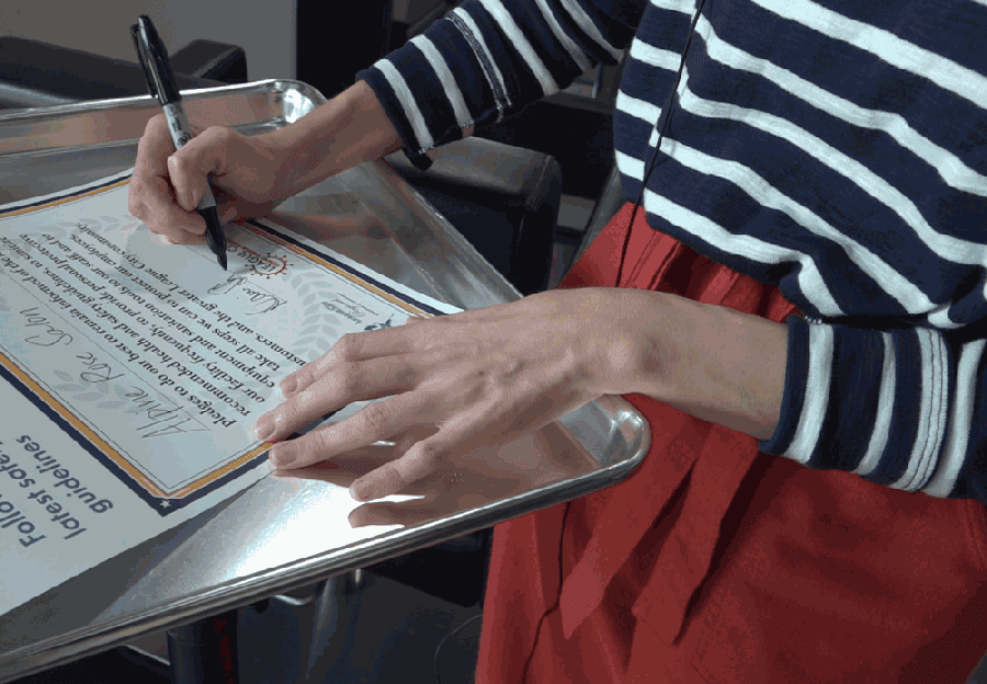 A business owner signs League City's pledge. (Courtesy city of League City)