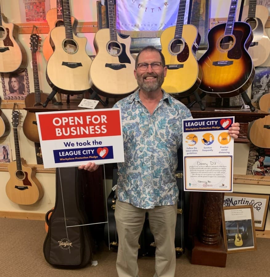 Danny Douglass of Danny D's Guitar Hacienda poses with pledge signs. (Courtesy city of League City)