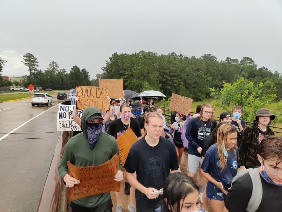 As rainfall let up, protesters circled back and forth across the Lake Woodlands Drive bridge. (Ben Thompson/Community Impact Newspaper)