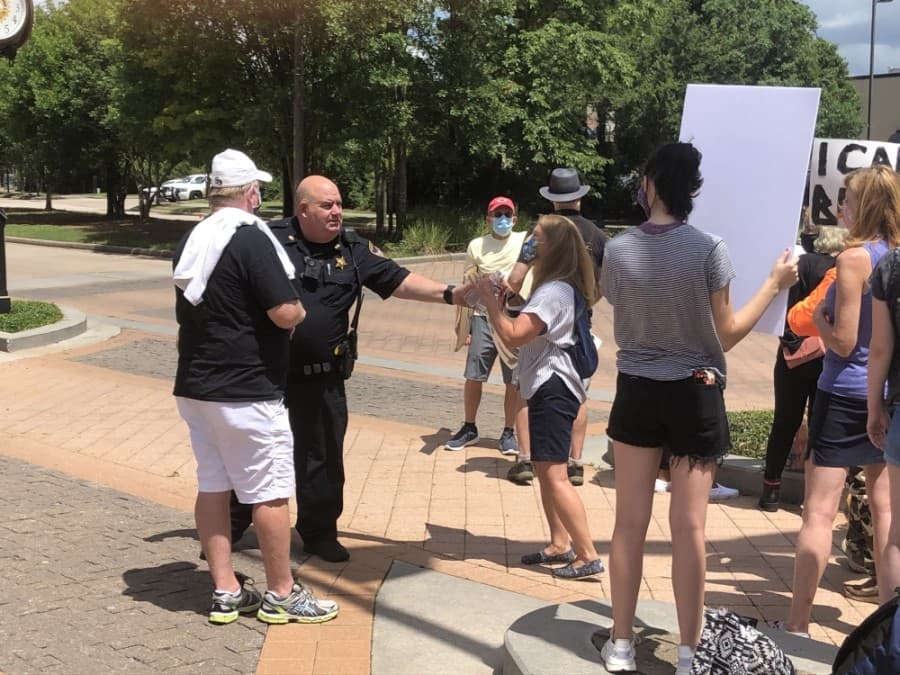 A member of the Montgomery County Sheriff's Office passed out waters to protestors and advised them to stay hydrated. (Andrew Christman/Community Impact Newspaper)
