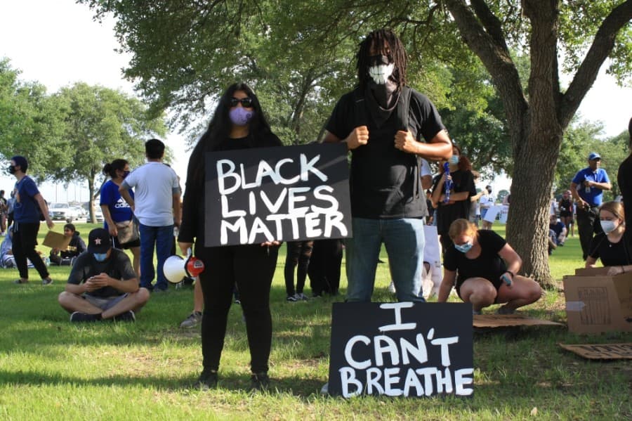 Two demonstrators share their signs at the Katy for Black Lives Matter Protest held June 4 at Katy Park.  (Jen Para/Community Impact Newspaper)