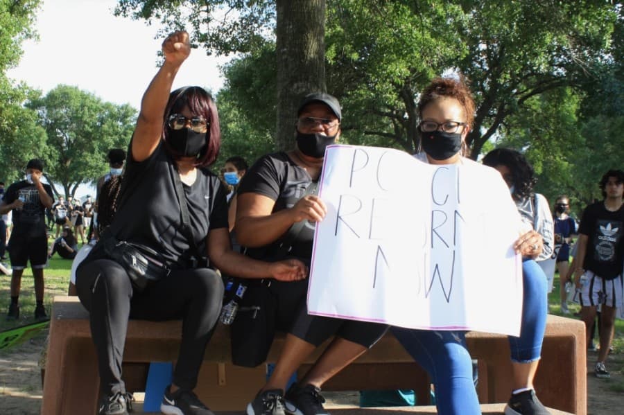 Three Katy for Black Lives Matter Protest attendees sat in the shade after the march June 4 at Katy Park. (Jen Para/Community Impact Newspaper)