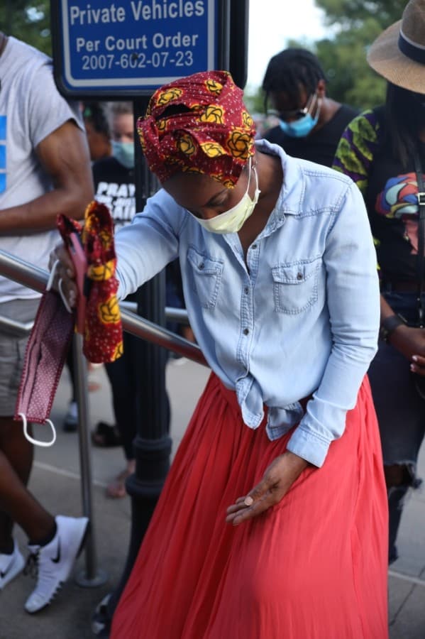 Jennifer Irozuru leaned against the railing of the courthouse stairs as she listened to prayers from Collin County pastors. (Liesbeth Powers/Community Impact Newspaper)
