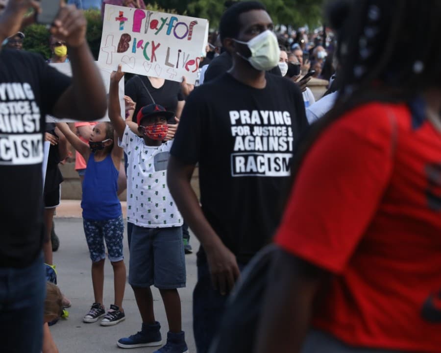 Children were encouraged to raise their voices at the gathering. A young boy jumped up with his sign in response. (Liesbeth Powers/Community Impact Newspaper)