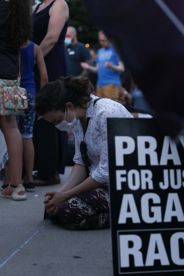 Some knelt to the ground in prayer as the evening drew to a close. (Liesbeth Powers/Community Impact Newspaper)