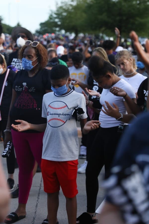 Those in the crowd lifted their hands during prayer at the June 4 prayer rally. (Liesbeth Powers/Community Impact Newspaper)