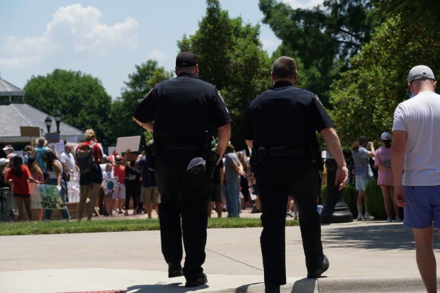 Police walk from the town hall towards the location of the protest. (Gavin Pugh/Community Impact Newspaper)