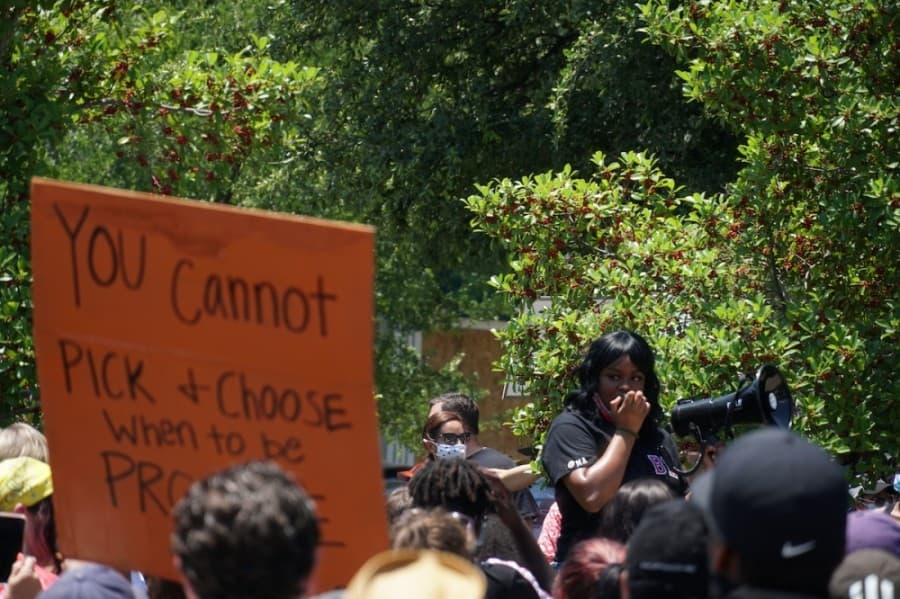 One of the organizers of the protest speaks at the center of the town square. (Gavin Pugh/Community Impact Newspaper)