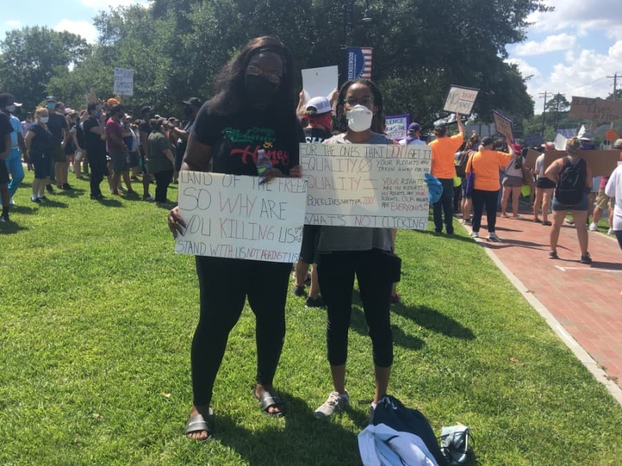 Protestors Tavon Jackson and Angela Arnold hold signs. (Haley Morrison/Community Impact Newspaper) 