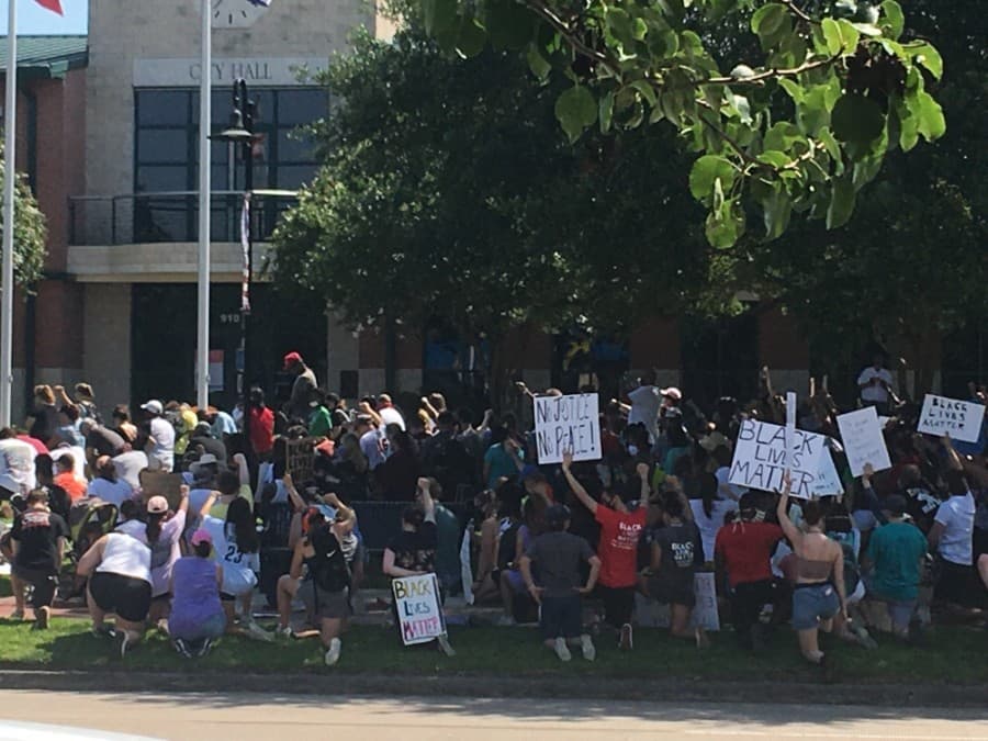 Protestors knelt in silence for 8 minutes and 56 seconds in front of Friendswood City Hall. (Haley Morrison/Community Impact Newspaper) 