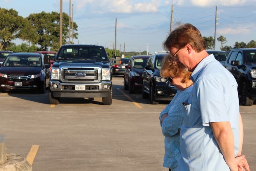 Members of the Magnolia community gathered to pray June 5 for unity amid unrest in the nation. Some gathered on the lawn in front of Magnolia High School while others stayed in their vehicles, listening in via an FM transmitter. (Anna Lotz/Community Impact Newspaper)