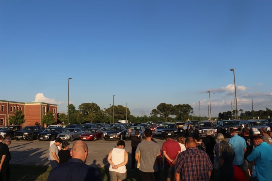 Members of the Magnolia community gathered to pray June 5 for unity amid unrest in the nation. Some gathered on the lawn in front of Magnolia High School while others stayed in their vehicles, listening in via an FM transmitter. (Dylan Sherman/Community Impact Newspaper)