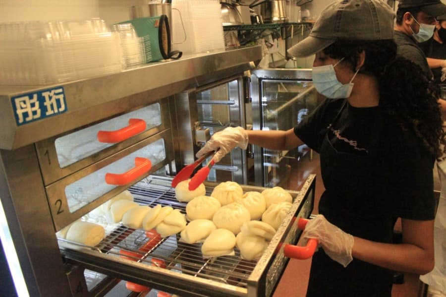 An employee at Bao'd Up prepares orders at the local restaurant's new location at Kitchen United Mix. (Jack Flagler/Community Impact Newspaper)