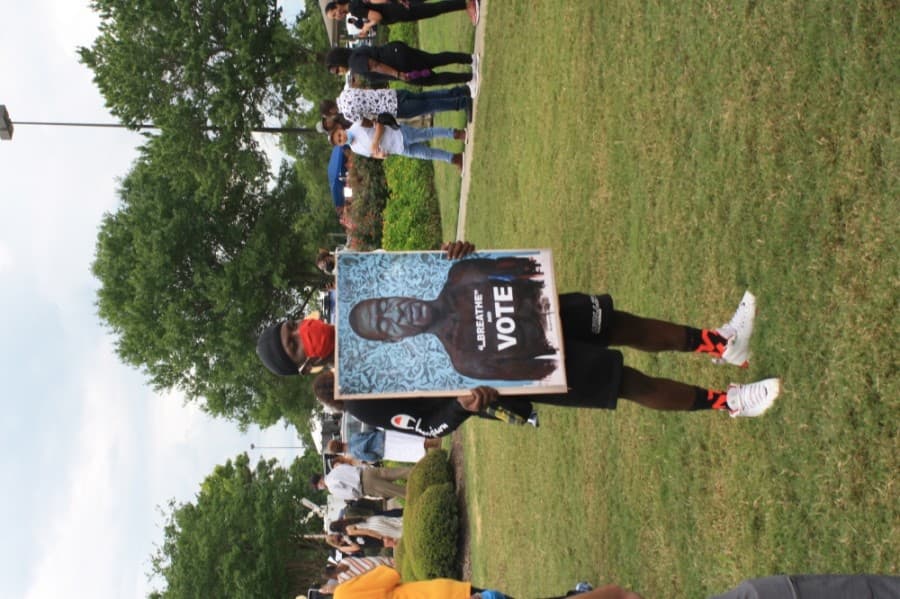 Some attendees at the memorial brought signs honoring George Floyd. (Jen Para/Community Impact Newspaper)