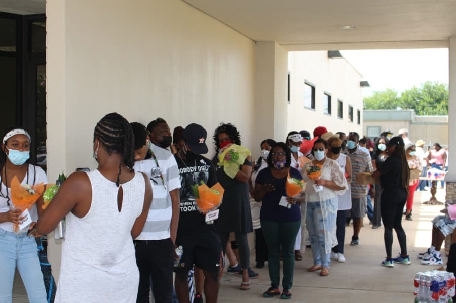 People wait in line for a shuttle to the visitation at the FountainLife Center in Houston. (Claire Shoop/Community Impact Newspaper)