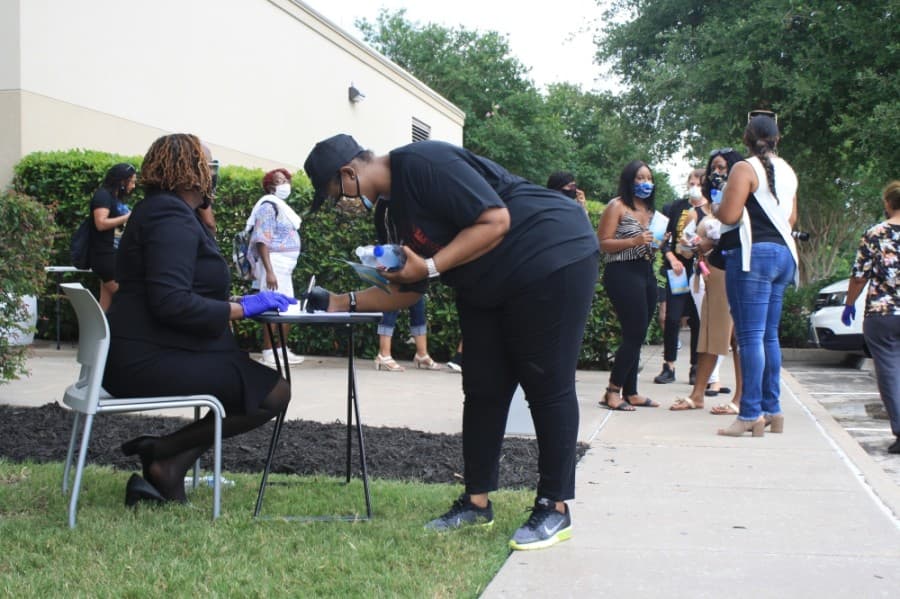Charmaine James signs the visitation book after viewing George Floyd’s casket and body at the June 8 Public Memorial for George Floyd at The Fountain of Praise in Houston. (Jen Para/Community Impact Newspaper)