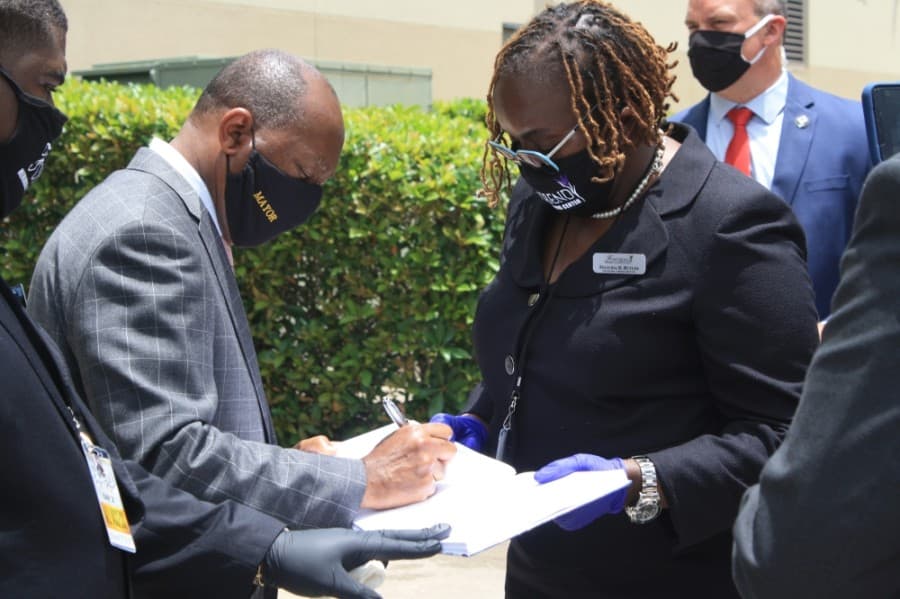 Houston Mayor Sylvester Turner signs the visitation book held by Felicia D. Butler, who is with the funeral home overseeing George Floyd’s body. (Jen Para/Community Impact Newspaper) 