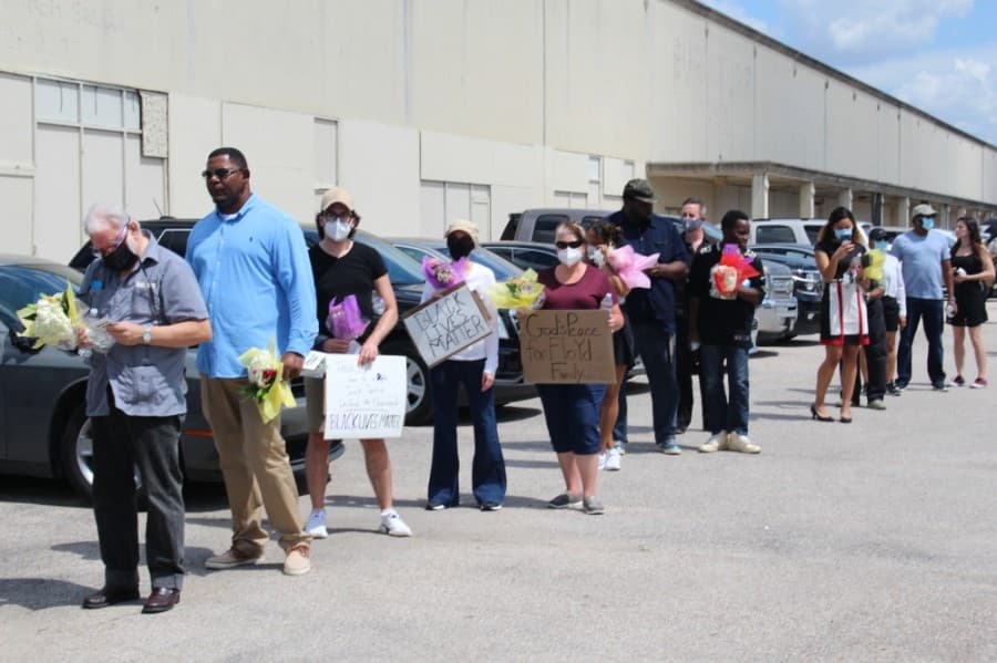 Some attendees at the memorial brought signs honoring George Floyd. (Claire Shoop/Community Impact Newspaper)