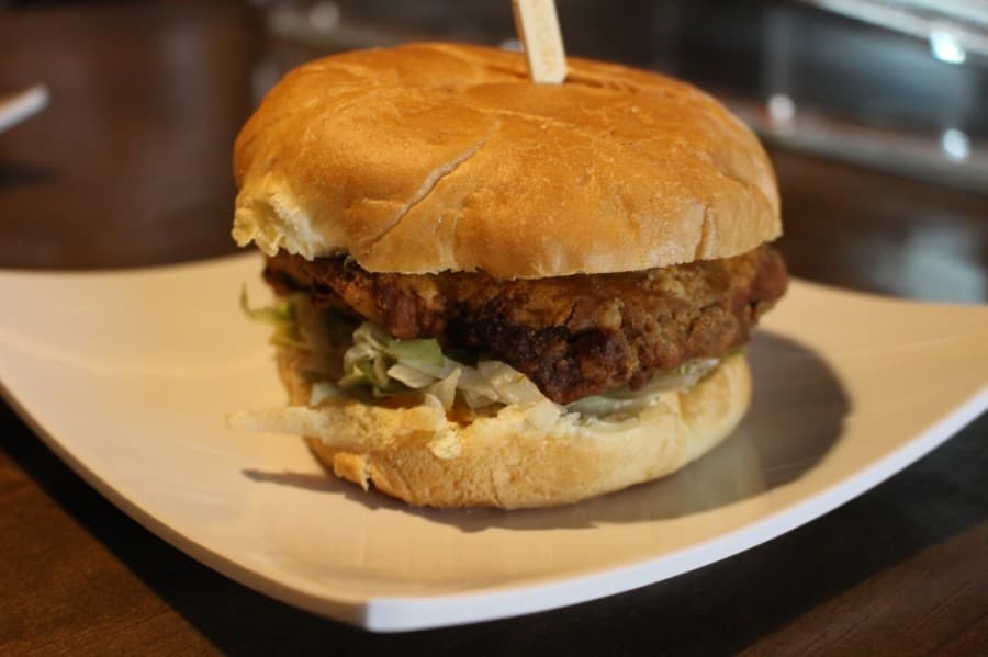 The Wisdom Vegan Bakery’s spicy “chicken” sandwich consists of homemade seitan, lettuce, tomato and spicy sauce. (Andrew Christman/Community Impact Newspaper)