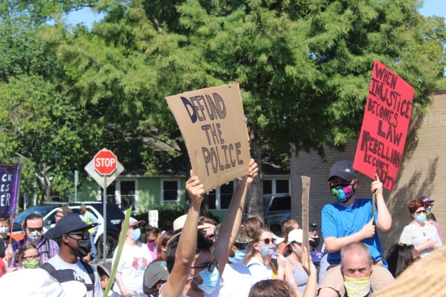 The group of protesters travel down Malone Street to City Hall. (Dylan Sherman/Community Impact Newspaper)