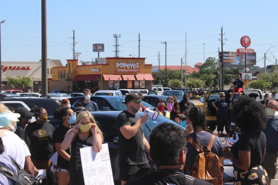 Reis Seggebruch, an organizer of the event, addresses the crowd of protesters in the H-E-B parking lot before venturing down West Main Street to City Hall on June 13. (Dylan Sherman/Community Impact Newspaper)