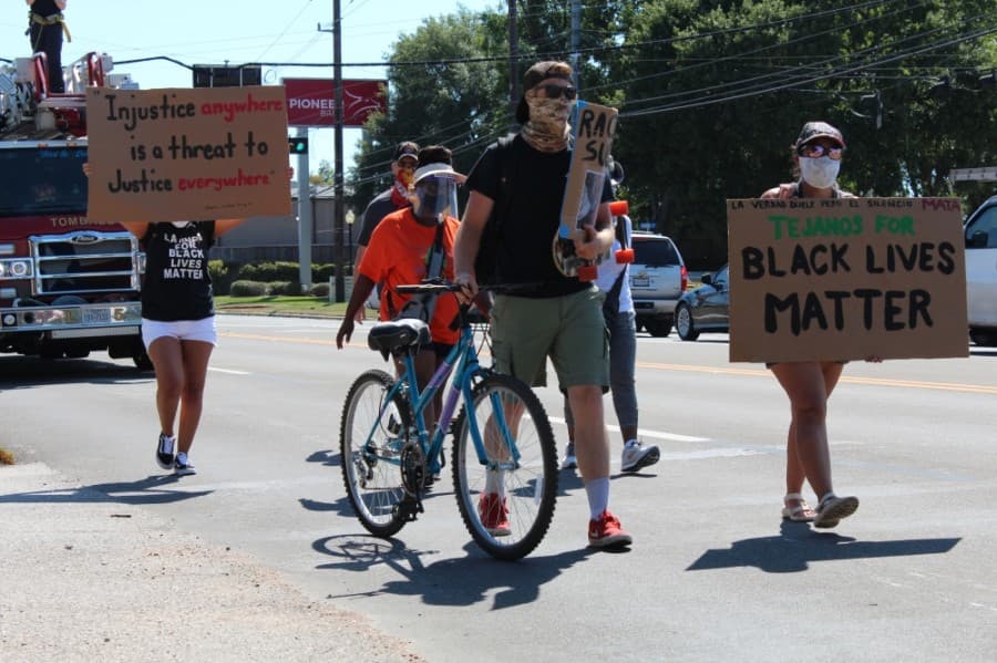 Protesters are escorted down one lane of West Main Street by the Tomball police and fire departments. (Anna Lotz/Community Impact Newspaper)