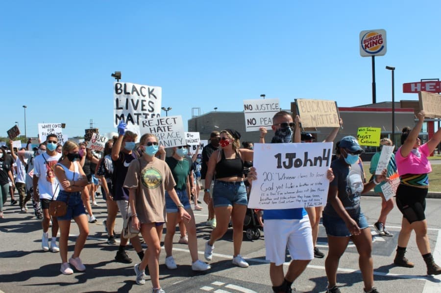 The group departs the H-E-B parking lot heading toward West Main Street on June 13. (Anna Lotz/Community Impact Newspaper)