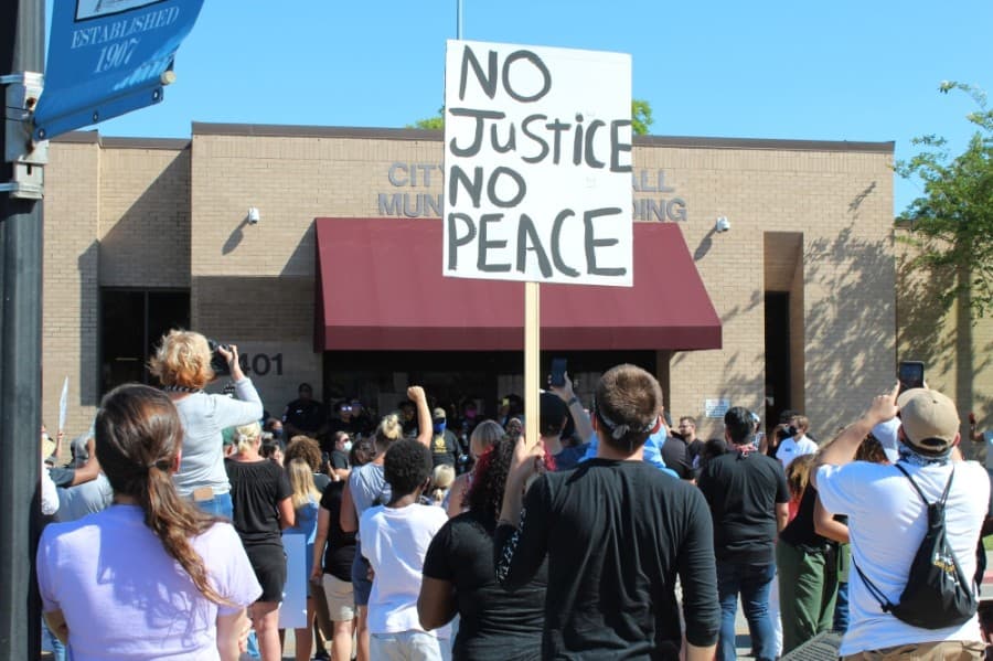 Speakers addressed the crowd gathered at Tomball City Hall on June 13. (Anna Lotz/Community Impact Newspaper)