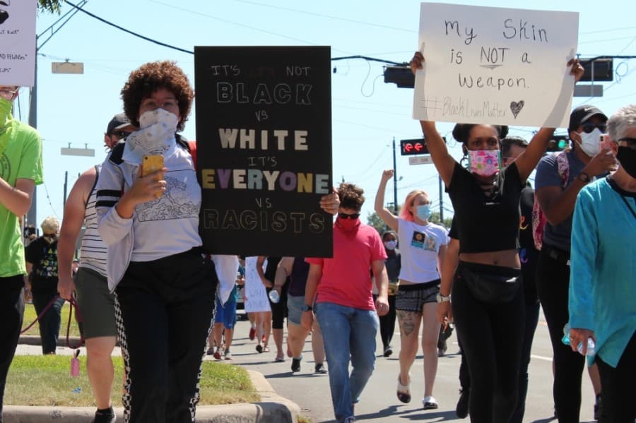 Protesters march down West Main Street with signs and chants on June 13. (Anna Lotz/Community Impact Newspaper)