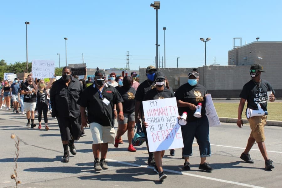 Representatives of the nonprofit Unity Gold led the march from the H-E-B parking lot heading toward West Main Street on June 13. (Anna Lotz/Community Impact Newspaper)