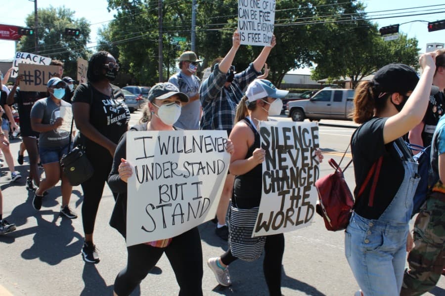 Protesters march down West Main Street with signs and chants on June 13. (Anna Lotz/Community Impact Newspaper)