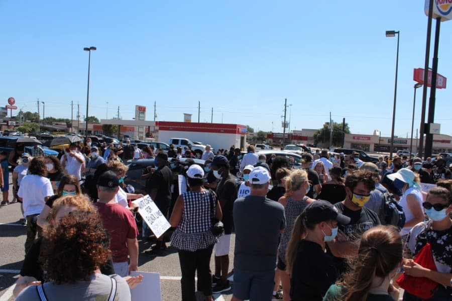 The group of a few hundred gathered in the H-E-B parking lot before the march. (Anna Lotz/Community Impact Newspaper)
