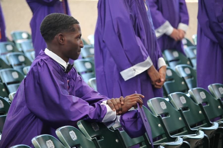 A student kneels during the National Anthem. (Andy Li/Community Impact Newspaper)