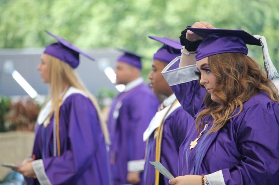 A WHS student adjusts their cap. (Andy Li/Community Impact Newspaper)