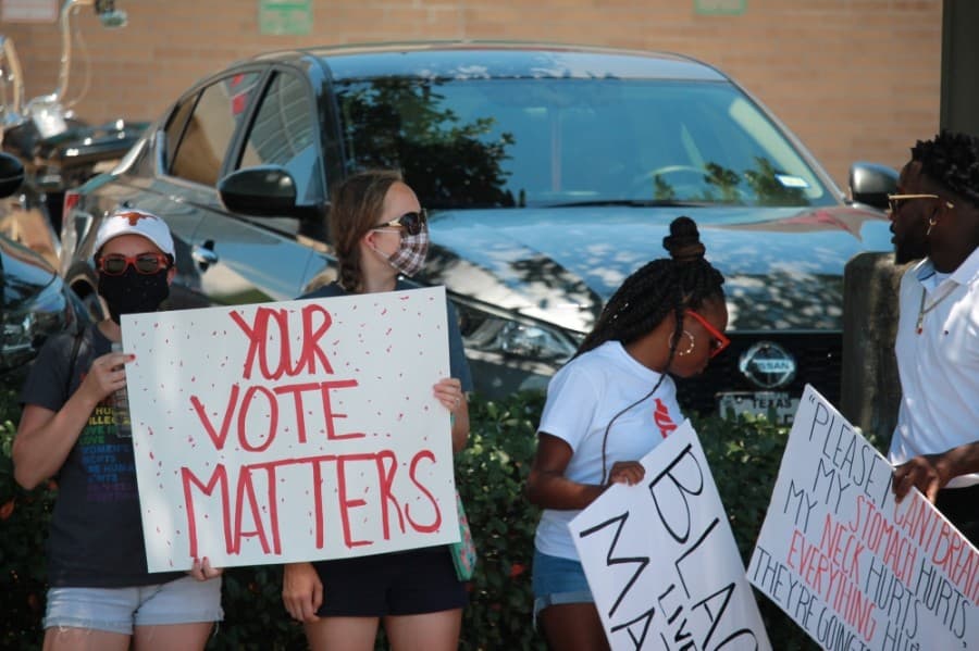 Protesters hold signs that say "Your Vote Matters." (Andy Li/Community Impact Newspaper)
