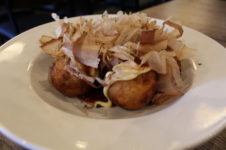 A popular appetizer is takoyaki, which is a baked octopus pastry with mayo, dried bonito flakes and takoyaki sauce. (Elizabeth Ucles/Community Impact Newspaper)
