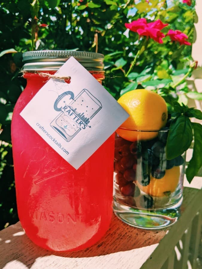 A photo of a bright pink drink mixer in a mason jar